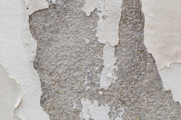 Abstract old white concrete wall with peeling paint.