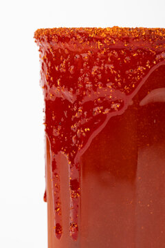 Michelada is a Mexican way of serving beer. In the image beer is mixed with tomato juice and other goodies and the glass is decorated with a frost of chamoy sauce and chili powder.