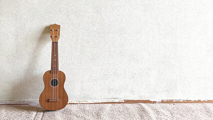 白壁に立てかけたウクレレ