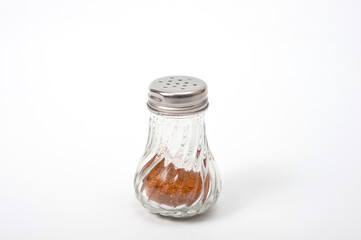 Glass container with a metal screw-on lid with holes for ground pepper.