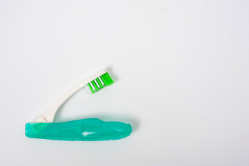 Folding plastic toothbrush for travel and tourism, shot on a white background.