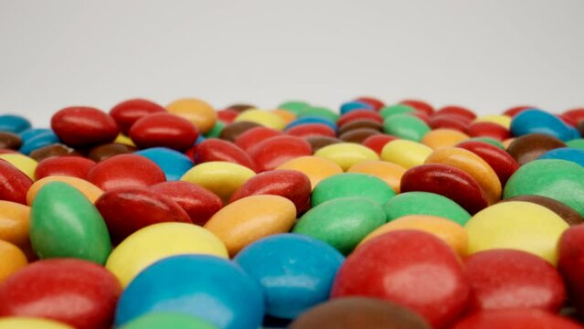 MACRO: Motion over colour candies on a white background, Dolly shot