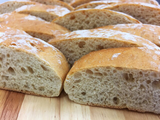 Fresh sliced baked breads closeup on the wooden board