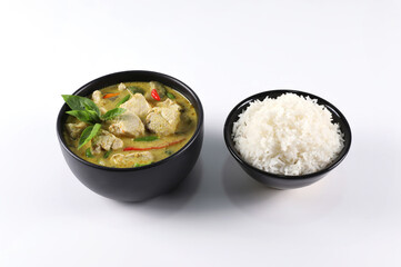 Thai food. Chicken green curry with rice in black bowl isolated on white background.