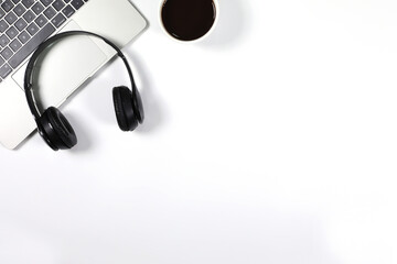 Black headphone placed on laptop with black coffee cup isolated on white background. Flat lay photography with copy space.