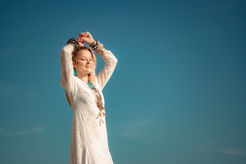 Woman in bohemian clothing on beach at sunset. Boho style for fashionable look on resort. Middle...