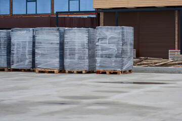 View of film-packed pallets with paving slabs.