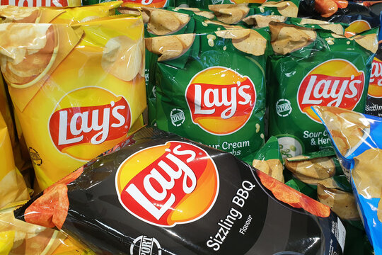 PENANG, MALAYSIA - 27 JAN 2022: Various choices of lay's potato chips for sale in grocery store. Lay's has been owned by PepsiCo through Frito-Lay since 1965.