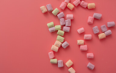 Multicolored candies on a pink background. Close-up