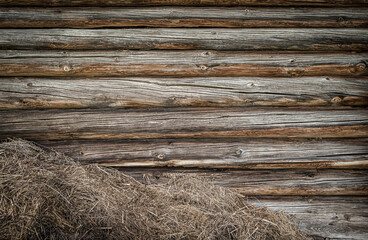 A pile of straw against a wooden wall. The old barn wall. Rustic background with a place to record.