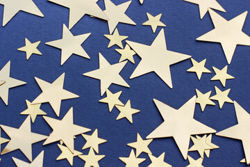 Golden stars glitter on blue background, selective focus. Festive holiday pastel backdrop.