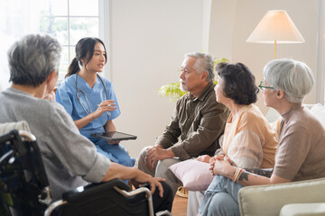 Group of Asian senior people sit in a circle in a nursing home and listen to nurse during a group elderly therapy session.