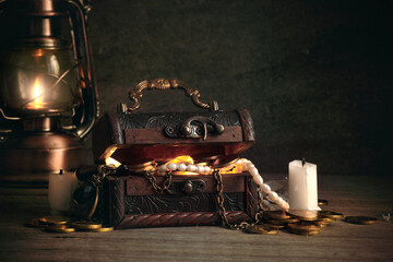 a chest with pirate treasures and jewels on a wooden table in the captain's cabin in retro style,...