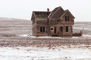 Abandoned Farm House in Snowy Field - Shallow Depth of Field