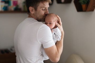 Father holding his newborn son at home.