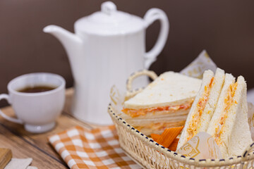 Sandwich or Bread stuffed with mix salad mayonnaise with tea or coffee pot and cup lunch break food served on table