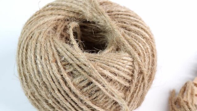 coiled raw rope Made of various fibers into a long rope. Empty with a small clip made of wood. For brown crafts, white background isolated, zoom out studio shot.