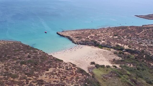 Aerial drone. Crystal clear turquoise waters at Calamosche, one of the most beautiful beaches in Sicily. Vendicari nature reserve near Noto, Siracusa.