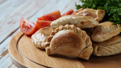 Latin American fried empanadas with tomato sauce. Argentinian Empanada is a pastry turnover filled with a variety of savory ingredients and baked or fried.
