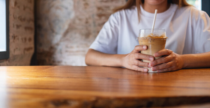 Closeup image of a young woman holding a glass of iced coffee