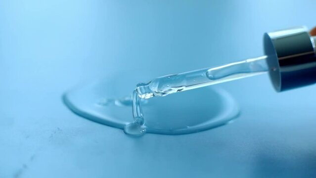 serum pipette with a falling drop on a blue background