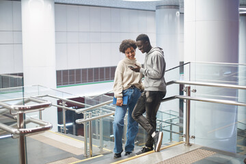 couple of students reading an email while standing in the subway