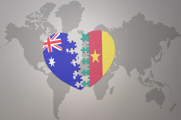 puzzle heart with the national flag of cameroon and australia on a world map background. Concept.