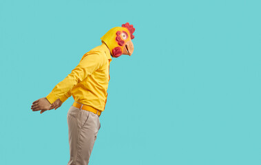 Guy in funny bird disguise getting ready to jump in water. Side view of young man wearing casual...