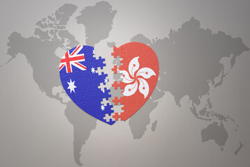puzzle heart with the national flag of hong kong and australia on a world map background. Concept.