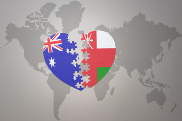 Obraz na płótnie Canvas puzzle heart with the national flag of oman and australia on a world map background. Concept.