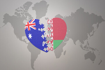 puzzle heart with the national flag of belarus and australia on a world map background. Concept.