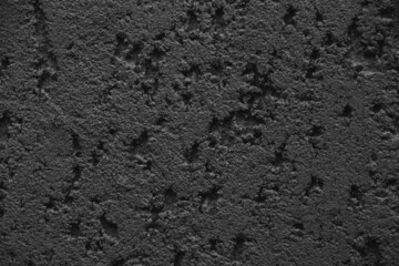 Black rough texture. Dark background with a close-up of a plaster texture pattern