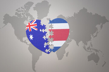 puzzle heart with the national flag of costa rica and australia on a world map background. Concept.