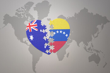 puzzle heart with the national flag of venezuela and australia on a world map background. Concept.