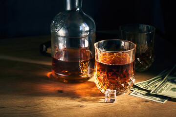 two glasses of iced whiskey and dollars