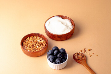ingredient for breakfast granola, greek yogurt, blueberry on beige background. top view