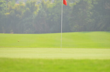 Obraz premium Red flag on a golf green