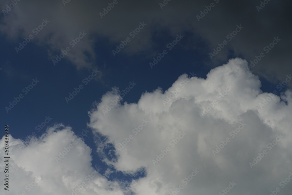 Wall mural Dichte und kompakte Bewölkung aus unterschiedlich geformten  Wolken am morgendlichen Himmel, blau und weiß