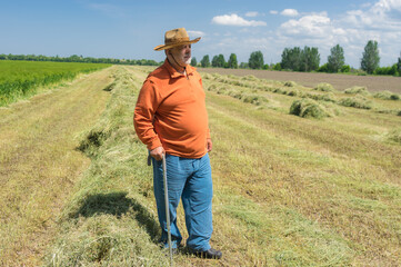 Naklejka na ściany i meble Full body portrait of bearded Caucasian senior farmer standing agricultural field in central Ukraine and looking forward