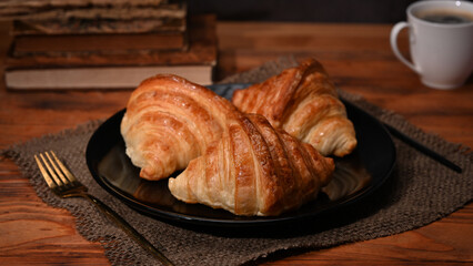 Homemade butter croissants on wooden table with coffee cup for breakfast