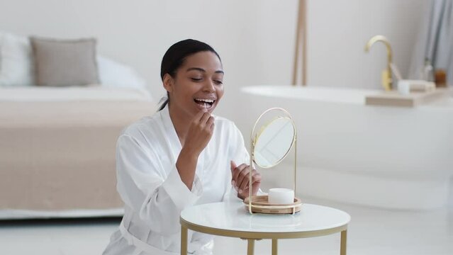Dental hygiene concept. Young happy african american lady flossing her teeth with special floss stick in morning