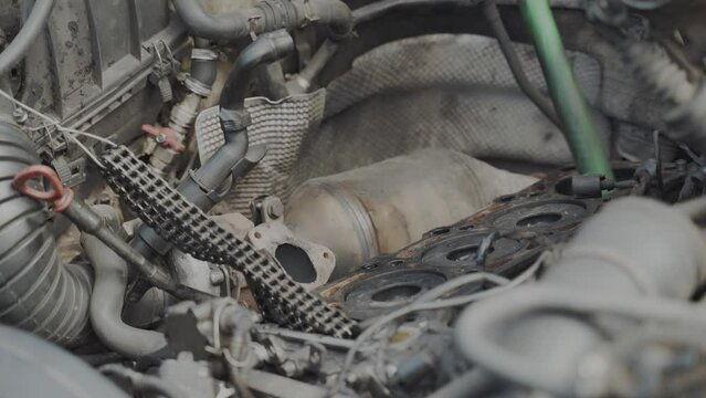 Auto mechanic serviceman assembles the car engine and installs the piston with new rings