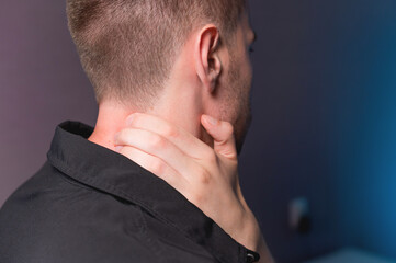 Fototapeta premium Close-up of a man independently kneading his neck and neck muscles long extensors of the neck. Neck pain