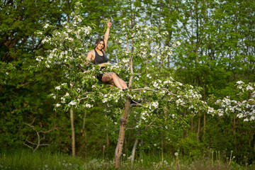 Size plus woman climbing an apple tree