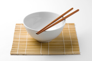wooden chopsticks on a white bowl isolated on white background.
