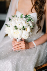 bride in a white dress with a chic bouquet in her hands. Luxury wedding bouquet. The girl is holding flowers - roses, peonies, archedes.
