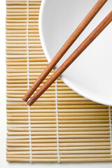 wooden chopsticks on a white bowl isolated on white background.
