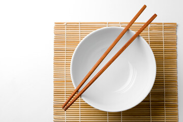 wooden chopsticks on a white bowl isolated on white background.
