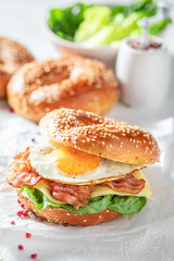 Delicious and homemade bagels with bacon and fried egg.