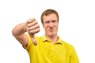 Unhappy annoyed man in yellow T-shirt showing thumbs down gesture isolated on white background
